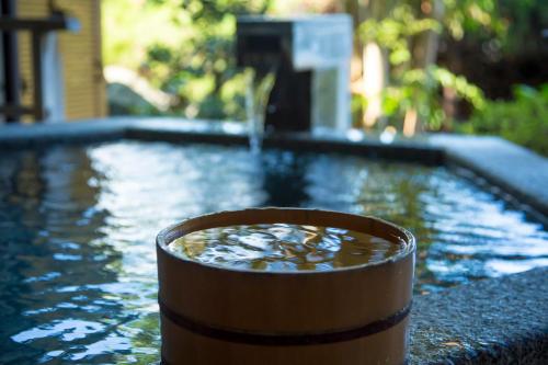 a pool of water with a wooden barrel in front of it at Hotel Kitanoya in Miyazu