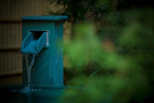 a blue bird feeder with water coming out of it at Hotel Kitanoya in Miyazu