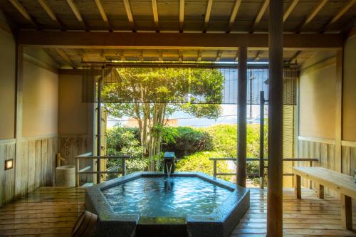 a hot tub on the deck of a house at Hotel Kitanoya in Miyazu