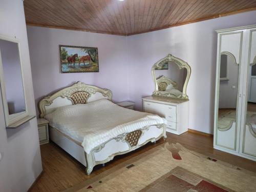 a bedroom with a white bed and a mirror at Гостевой Дом Чолпон-Ата in Cholpon-Ata