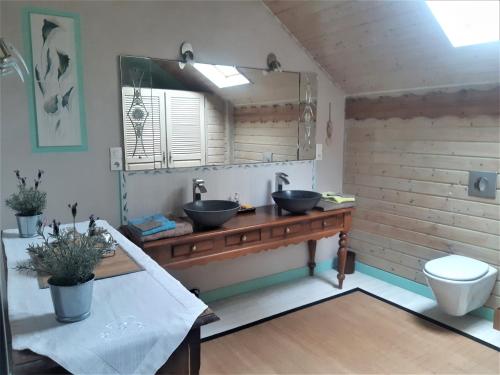uma casa de banho com 2 lavatórios num balcão de madeira em le Trésor de Gabaret em Burosse-Mendousse