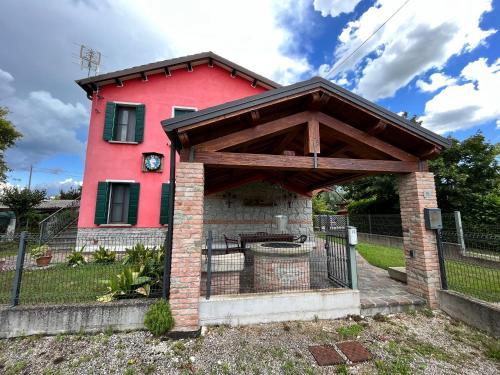 a red house with a brick oven in front of it at Ca' De Franceschi in Teolo