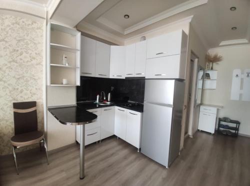 uma cozinha com armários brancos e um balcão preto em Meskheti Tower Unit 93 em Akhaltsikhe
