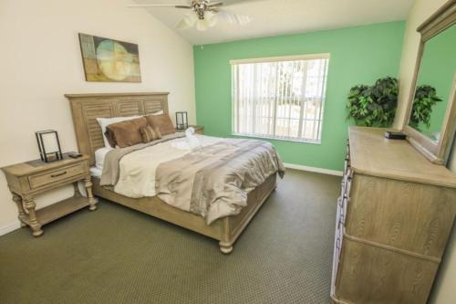 una camera da letto con pareti verdi, un letto e una finestra di 3 Bedroom Resort Condo 8 Miles to Disney Pool Free Parking a Kissimmee