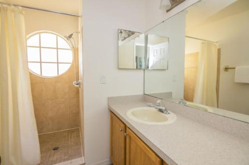un bagno con lavandino, doccia e specchio di 3 Bedroom Resort Condo 8 Miles to Disney Pool Free Parking a Kissimmee
