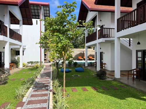 a courtyard with a tree in the middle of a building at Lum Residence in Ahangama