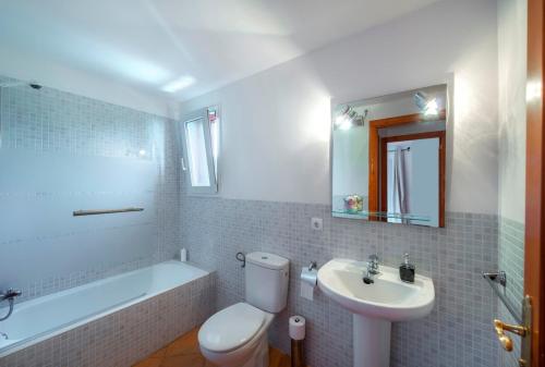 a bathroom with a sink and a toilet and a bath tub at Villa Cala Pi in Cala Pi