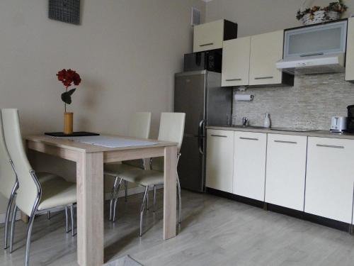 een keuken met een tafel en stoelen en een koelkast bij Apartament w centrum Starego Miasta 1 in Olsztyn