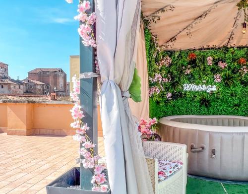 una marquesa con flores al lado de un edificio en Colosseum Exclusive Apartment - Private Rooftop with Hot Tub and Stunning View, en Roma