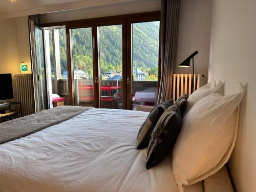 une chambre avec un lit avec des oreillers et une fenêtre dans l'établissement Center & Unique Mountain View, à Chamonix-Mont-Blanc