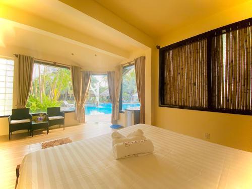 a bedroom with a bed and a large window at Jaguar House Resort Muine in Mui Ne