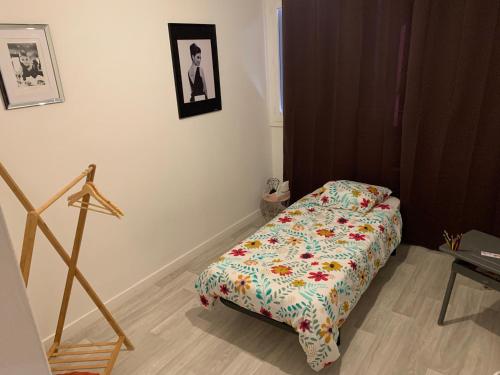 1 dormitorio con 1 cama con edredón de flores en Appartement idéal famille 3 chambres, en Mâcon