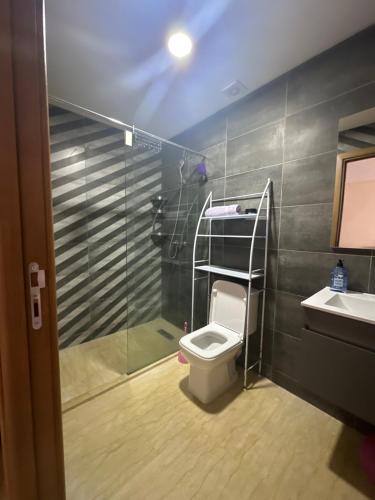 a bathroom with a toilet and a shower and a sink at App à côté du parc et corniche in Mohammedia