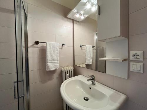 uma casa de banho branca com um lavatório e um espelho em All'ombra del Carmine em Pádua