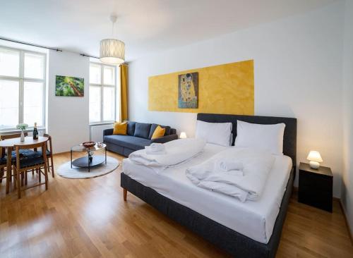 a bedroom with a large bed and a living room at Sunny and Stylish - Free Parking - 15 min to Center in Vienna