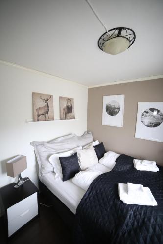 een slaapkamer met een zwart-wit bed en een lamp bij BraMy Apartments The Cozy View in Tromsø