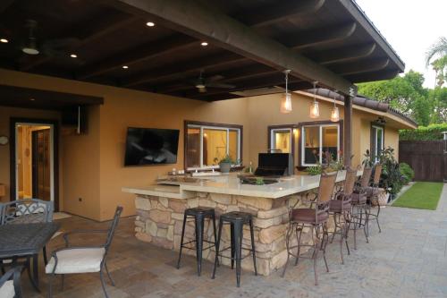 a patio with a bar with chairs and tables at Cottage On The Greens - Studio in Poway