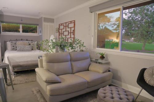 een woonkamer met een bank en een bed bij Cottage On The Greens - Studio in Poway