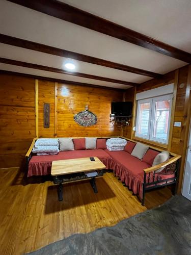 een woonkamer met een rode bank in een hut bij Medi Apartman Nature Connection Drina in Bajina Bašta