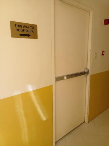 a door with a sign that reads this way to roof deck at Cityland Tagaytay with Swimming Pool and Viewing Deck in Tagaytay