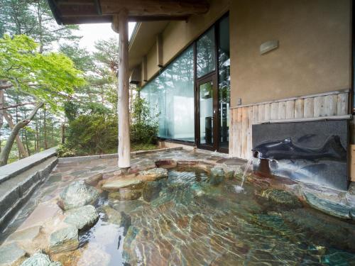a pond in the middle of a house with a fireplace at Jodogahama Park Hotel in Miyako