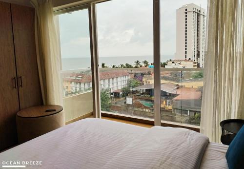 ein Schlafzimmer mit einem Bett und einem großen Fenster in der Unterkunft Ocean Breeze by DOXA in Negombo