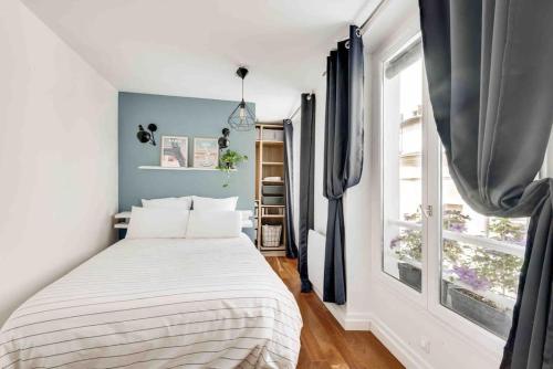 een slaapkamer met een bed en een groot raam bij MARAIS - Rue au maire - Chinatown in Parijs