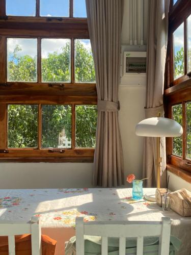 a dining room with a table and two windows at Suksamer Relaxation Homestay 