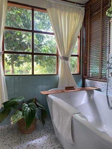 e bagno con finestra e vasca. di Suksamer Relaxation Homestay 
