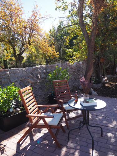 two chairs and a table on a patio at Casa de los Abuelos Albino in Pinilla del Valle