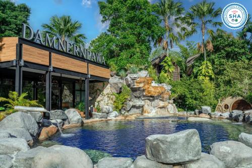 a swimming pool in front of a restaurant at DAMNERNPAWA in Bang Khon Thi