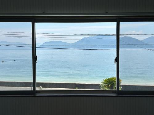 a view of the ocean from a window at Beach Villa Tachibana in Onomichi