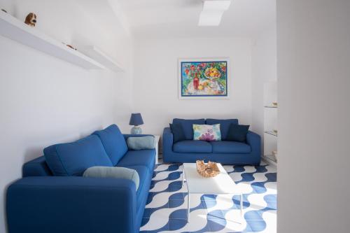 een woonkamer met twee blauwe banken en een tapijt bij Villa Sterlizia in Capri