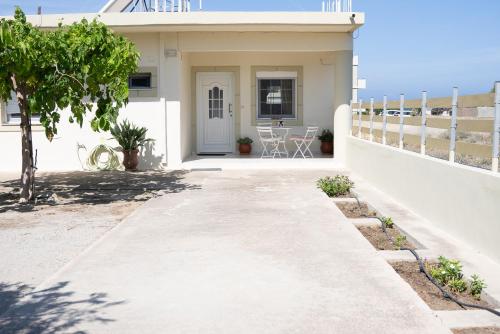 a white house with a pathway leading to the front door at GARDEN HOUSE, Kalamaki in Tympáki