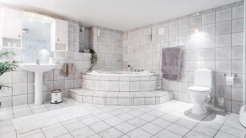 La salle de bains est pourvue d'une baignoire, de toilettes et d'un lavabo. dans l'établissement BraMy Apartments The LUX View, à Tromsø