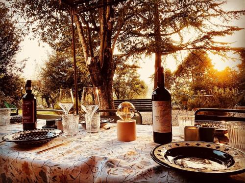 una mesa con dos botellas de vino y copas en Agriturismo CasaViVa, en Pozzo