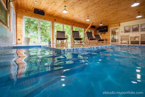 a swimming pool in a house with a wooden ceiling at Orzechowy domek in Torzym