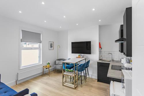 a kitchen with a table and chairs in a room at Modern 3 and 2 bedroom apartment in Maida Vale in London