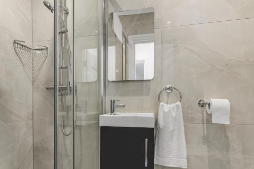 uma casa de banho com um lavatório e um chuveiro em Modern 3 and 2 bedroom apartment in Maida Vale em Londres