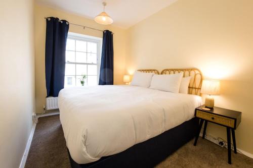 a bedroom with a large white bed and a window at Sea Downs - moments from beach in Eastbourne