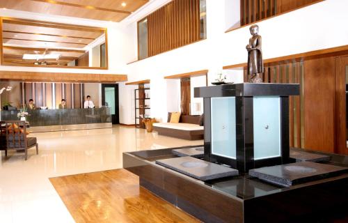 a living room with a statue on top of a table at Kantary Hills Hotel, Chiang Mai in Chiang Mai