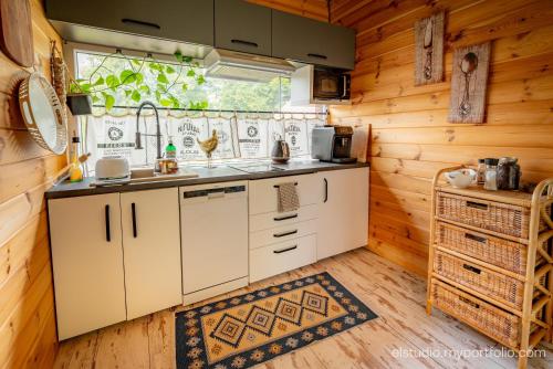 a kitchen with white cabinets and a window at Orzechowy domek in Torzym