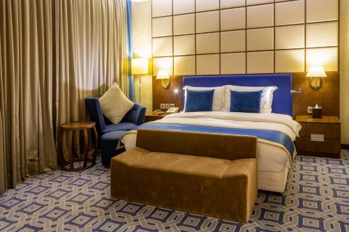 a hotel room with a large bed and a chair at Radisson Blu Hotel & Resort, Sohar in Sohar