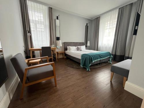 1 dormitorio con 1 cama, mesa y sillas en Hotel am Markt en Wipperfürth