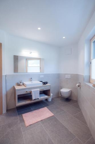 a bathroom with a tub and a toilet and a sink at Apart Eder in Schwendau