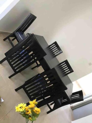 two black benches in a room with a vase of flowers at KareBer Deluxe - Gulu - Uganda in Gulu