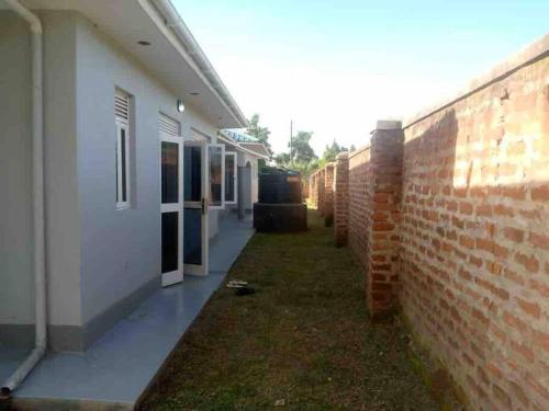 a side view of a building and a brick wall at KareBer Deluxe - Gulu - Uganda in Gulu
