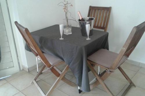a table with two chairs and a gray table cloth on it at Le Coton Verde , 2 nuits minimum in Sainte-Rose