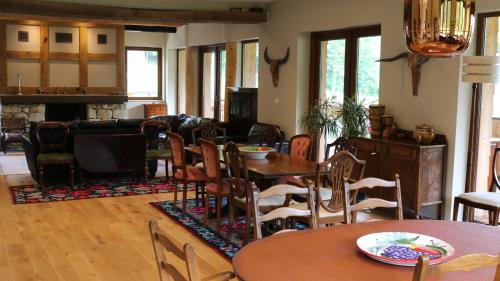- un salon avec des tables, des chaises et une cheminée dans l'établissement Pensiunea Tudorilor, à Văleni-Stînişoara