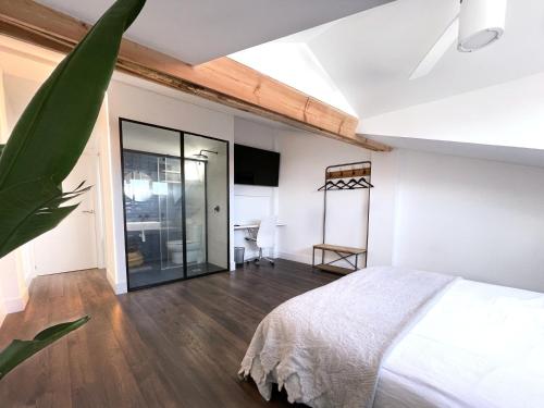 1 dormitorio con 1 cama y puerta corredera de cristal en Luxury Pintoreria Atico, en Vitoria-Gasteiz